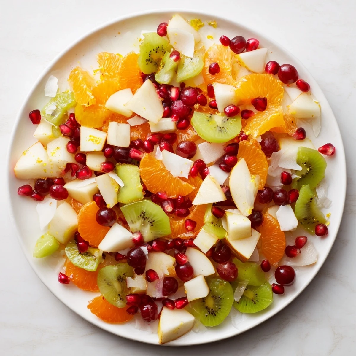 Snowflake Fruit Medley glistens with vibrant pomegranate arils, grapes, and kiwi, perfect as a refreshing winter dessert.