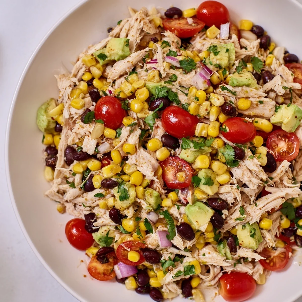 Creamy avocado tops the refreshing Dense Southwestern Bean Salad, perfect for a summer gathering.