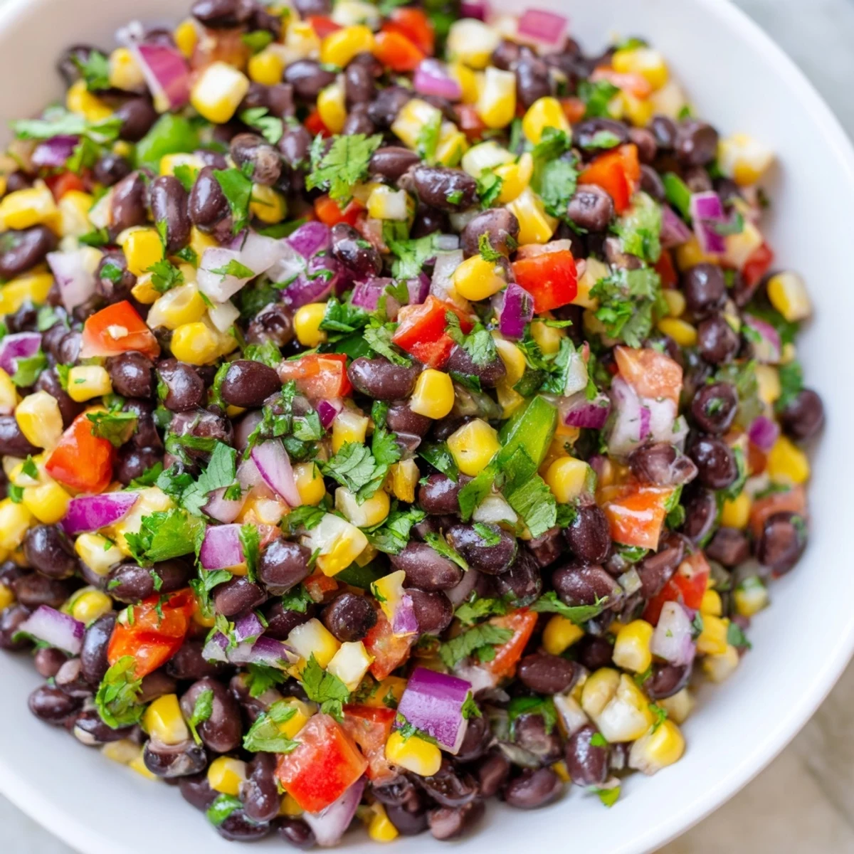 Cowboy Caviar Salad: A colorful bowl of black beans, corn, peppers, and red onion, ready to eat.