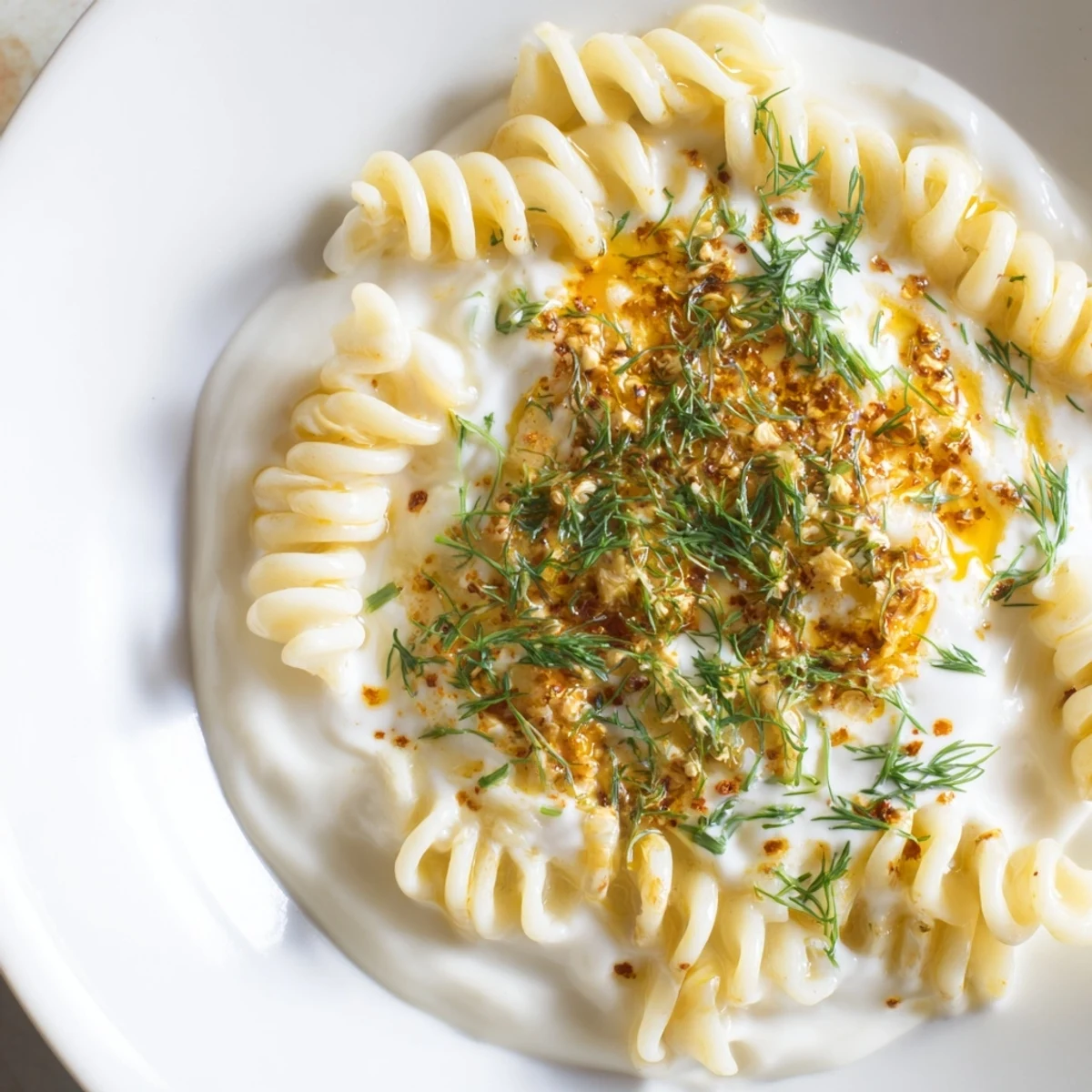 This Turkish Yogurt Pasta showcases swirls of pasta, coated in a garlic-infused yogurt sauce, and drizzled with fragrant butter.