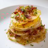 Close-up of Simple Fried Potatoes with Onions & Bacon: fried potatoes, bacon, and onions glistening.