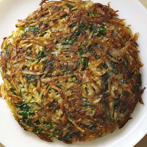 Crispy golden potato & spinach rösti, a flavorful Swiss-inspired skillet cake, ready to eat.
