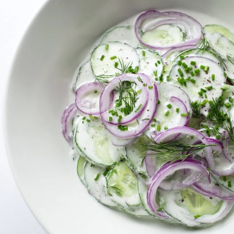 Creamy German Cucumber Salad, layered with sliced cucumbers and a creamy, herb-speckled dressing, ready to enjoy.