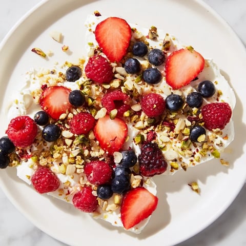 Frozen fruit yogurt bark, a colorful frozen treat, layered with berries and granola pieces.