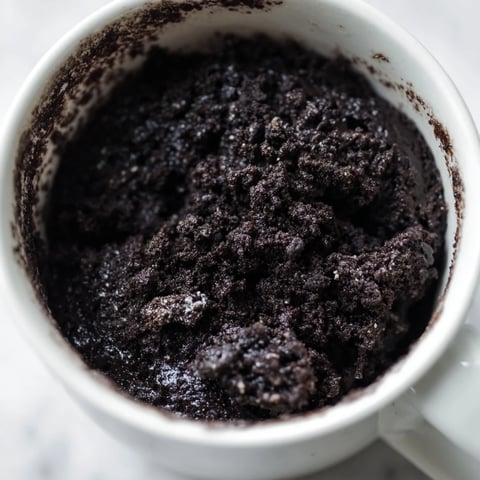 Rich, moist Oreo mug cake, a quick chocolate dessert with crumbled cookies and vanilla extract.