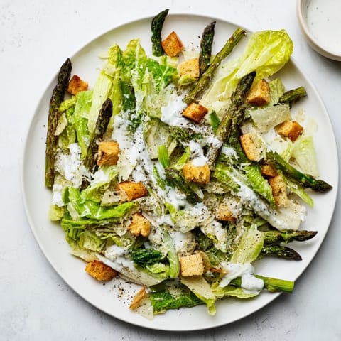 Gegrillte Spargelspitzen auf knackigem Römersalat mit hausgemachten Croutons und cremigem Joghurt-Caesar-Dressing.