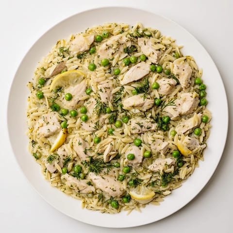 Zitronen-Kräuter-Hähnchen-Orzo-Skillet mit golden gebratenem Hähncheffleisch, frischen Kräutern und erbsen in einer cremigen, zitronigen Brühe.