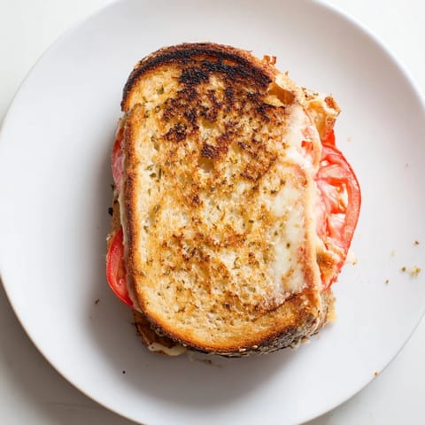 Ein geröstetes Sandwich mit Pepper Jack, geschmolzenem Käse und frischen Tomatenscheiben auf gewürztem Brot für die Mittagspause.