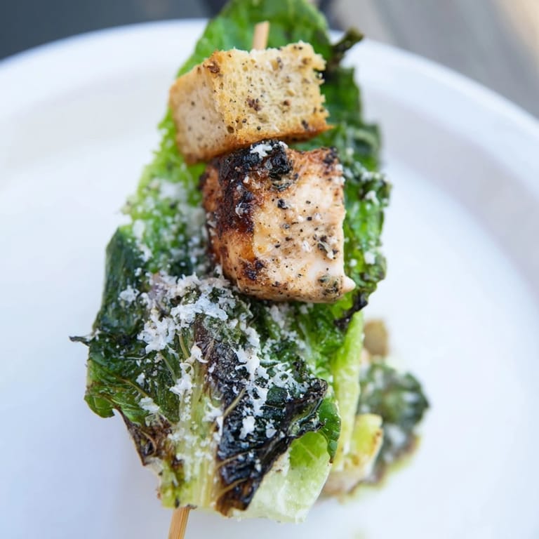 Close-up photo of Chicken Caesar Salad Skewers arranged with Caesar dressing for a refreshing appetizer.
