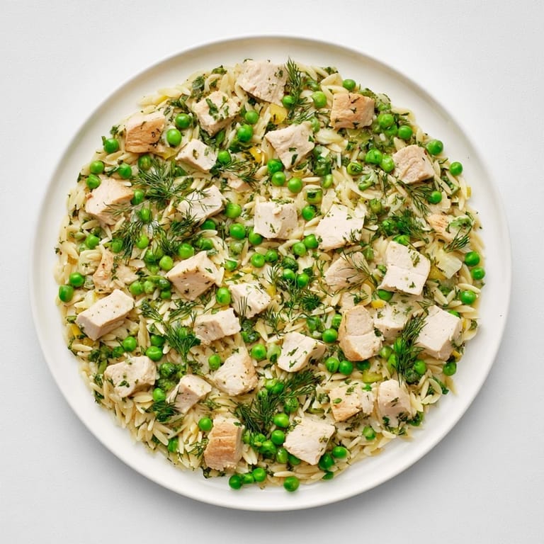 Dieses eintöpfige mediterrane Rezept zeigt zartes Hähnchen und Orzo in einer glänzenden Zitronensauce mit frischem Dill und Petersilie.